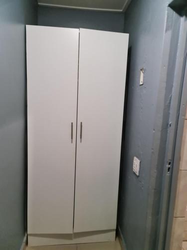 a locker room with two white cabinets in a room at Hasate Guest House 10 Florence street Oakdale Belliville 7530 cape town south African in Cape Town