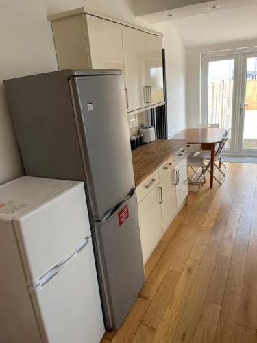 a kitchen with a refrigerator and a table at private room 6 in Bristol