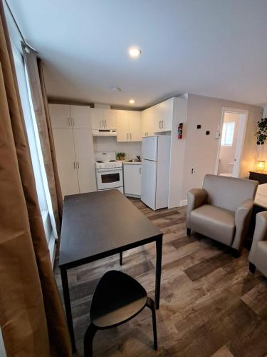 a small living room with a table and a kitchen at Habitations Zenith in Sainte-Anne-de-Beaupré