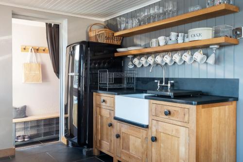a kitchen with a sink and a refrigerator at 2 Clifton Place in Salcombe