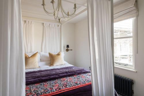 a bedroom with a bed with pillows and a window at 2 Clifton Place in Salcombe