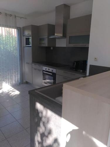 - une cuisine avec un comptoir blanc dans une pièce dans l'établissement Maison proche de la mer, au Barcarès