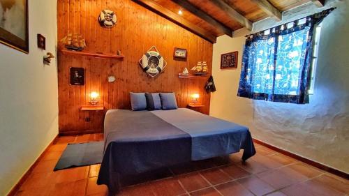1 dormitorio con 1 cama en una habitación con paredes de madera en Castelo de Bode Monte do Valinho Country house with private pool and panoramic views, en Alverangel