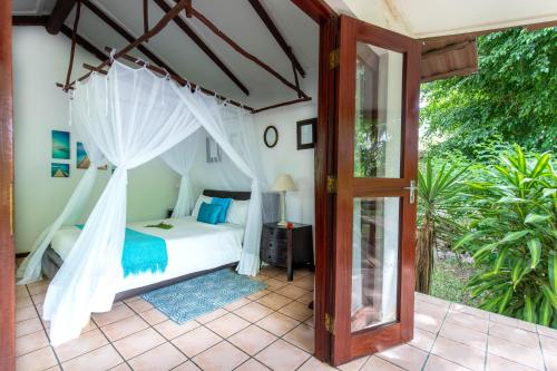 a bedroom with a bed with a mosquito net at LEMON BEACH LODGE Vilankulo in Vilanculos