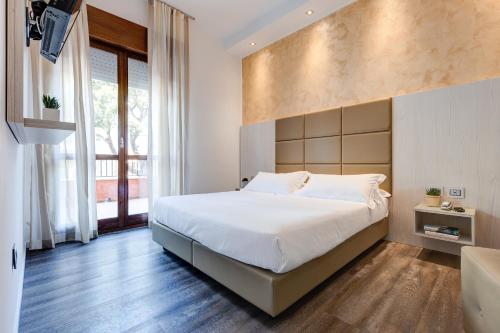 a bedroom with a large bed and a large window at Hotel Piccadilly in Lido di Jesolo