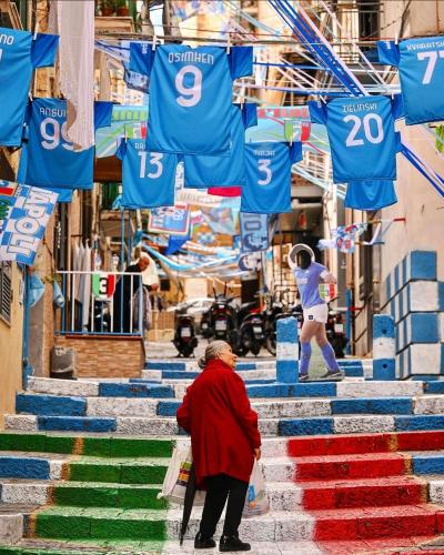 a person walking down stairs with colorful stairs at Il Rifugio Dei Partenopei in Naples