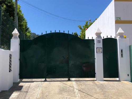 a green gate in front of a white building at Casa Martins Country Apartment No5 in Freiria