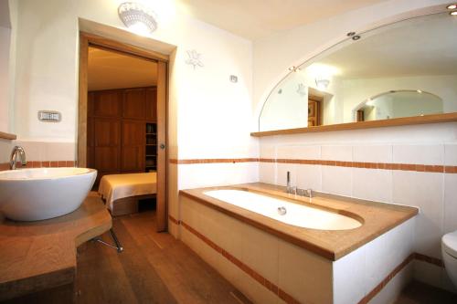 bagno con vasca, lavandino e specchio di Stazzo Liccia Barria a Arzachena