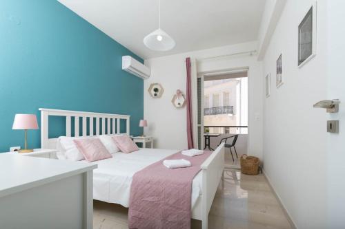 a bedroom with a bed with a pink blanket at In the heart of the city in Heraklio