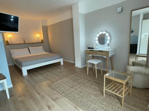 - une chambre avec un lit, une table et un miroir dans l'établissement La Pecora Nera B&B, à Budoni