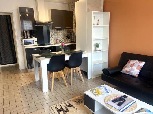 kuchnia i salon ze stołem i krzesłami w obiekcie Le Saint-Amour 2 w mieście Saint-Amour
