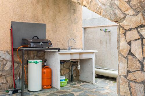 een keuken met een wastafel en een tafel met een grill bij Villa Denis Completa in Vidreres