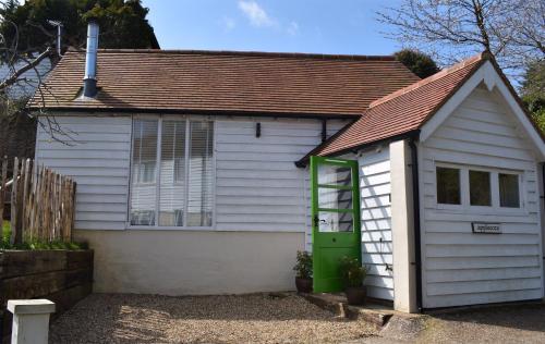 ein kleines weißes Haus mit grüner Tür in der Unterkunft Applecote a studio apartment for two Rye, East Sussex in Rye