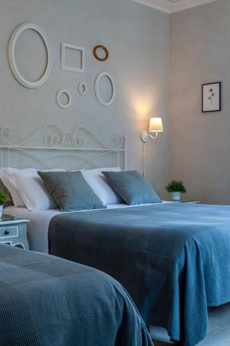 a bedroom with two beds with blue sheets at Villa Liberty Urbino in Urbino