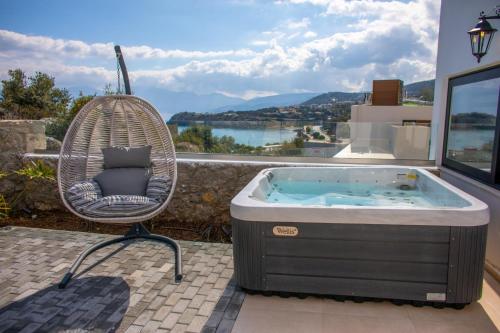 a swing chair sitting next to a hot tub at Beach Walk Luxury Suites in Agios Nikolaos