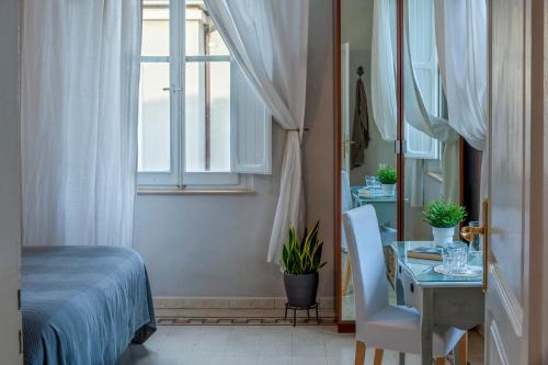 a bedroom with a table and a bed and a window at Villa Liberty Urbino in Urbino