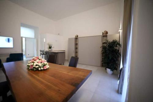 a room with a large wooden table with flowers on it at NANNI LOFT HOUSE in Castellammare di Stabia