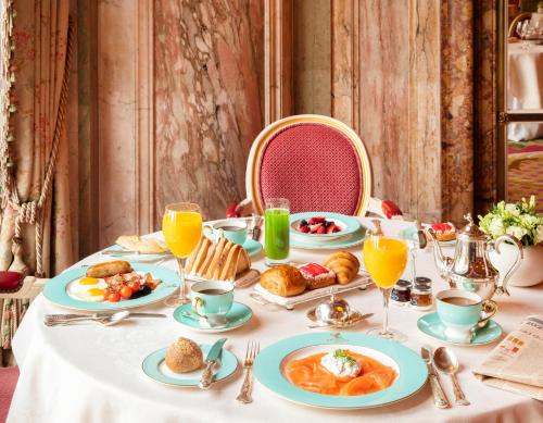a table with breakfast foods and orange juice on it at The Ritz London in London