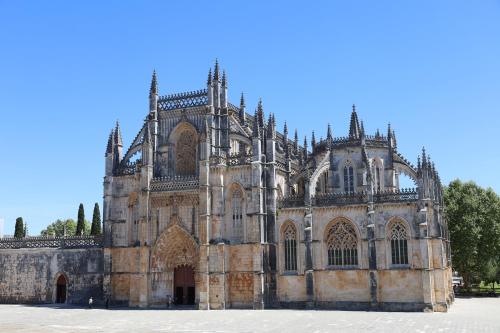 an old stone cathedral with a blue sky in the background at Hotel Dom Goncalo & Spa in Fátima