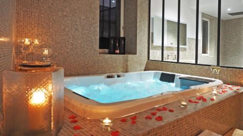 eine große Badewanne mit blauem Wasser im Badezimmer in der Unterkunft Chambre d'Hôtes Les Variétés in Saint-Rémy-de-Provence