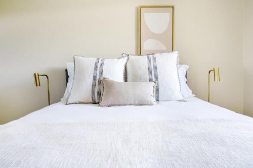 Una cama con sábanas blancas y almohadas. en Foster City 2BR w Gym Pool WD nr highways SFO-567, en Foster City