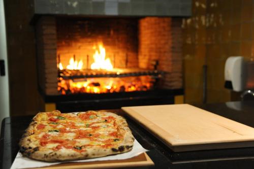 a pizza sitting on a counter in front of a fireplace at Il Casale Della Stella in Baronissi