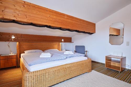 ライト・イム・ヴィンクルにあるFerienwohnung Breitschaft-Mühlbergerの木製の天井のベッドルーム1室(大型ベッド1台付)