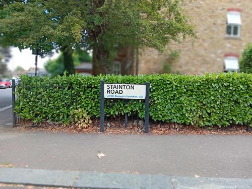 een bord dat zegt verzadigingsweg voor een heg bij Charming 2-Bed Apartment in London in Londen