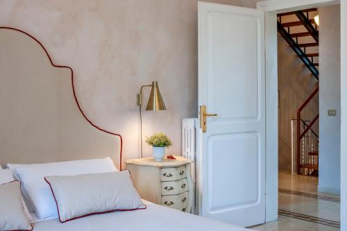 a bedroom with a bed and a table with a lamp at Villa Liberty Urbino in Urbino