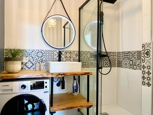 La salle de bains est pourvue d'un lave-linge et d'un miroir. dans l'établissement Le Saint-Jean - Climatisation, à Montauban