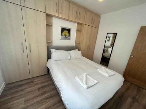 Un dormitorio con una cama blanca con dos servilletas blancas. en Westview House by Sasco Apartments en Blackpool