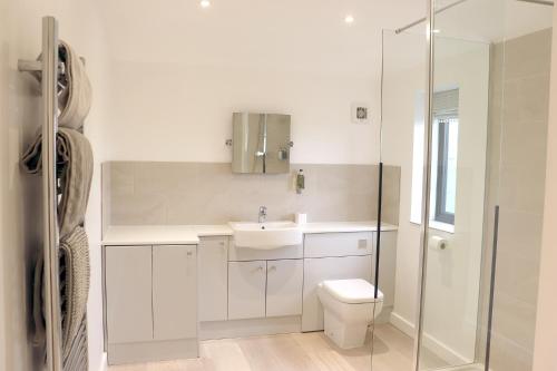 a white bathroom with a toilet and a sink at Cowley Farm, Preston Bissett, Buckingham in Buckingham
