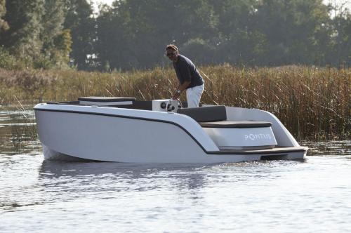 a man standing on a boat in the water at Dutchen Erfgoedpark De Hoop Glamping in Uitgeest
