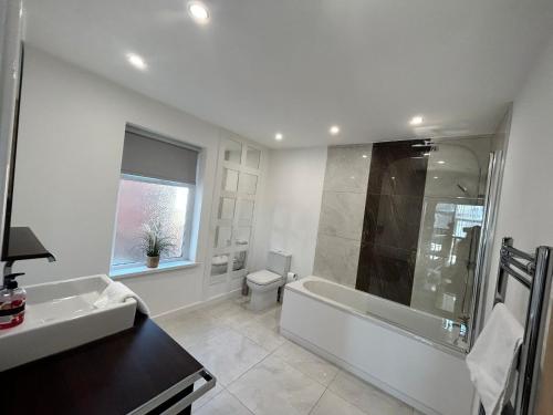 a bathroom with a tub and a toilet and a sink at Westview House by Sasco Apartments in Blackpool