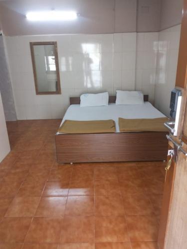 a bedroom with a bed and a mirror on the wall at Heera Residency in Tindivanam