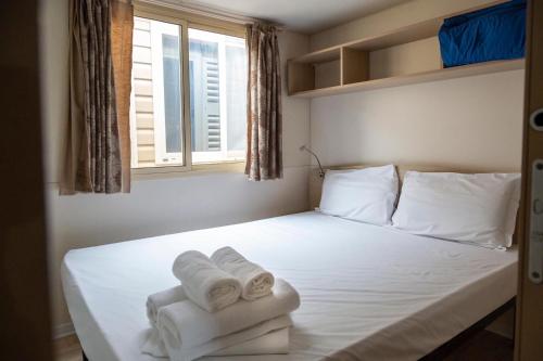 a bedroom with a bed with towels on it at Camping Village Costa Verde in Porto Potenza Picena