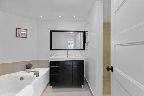 La salle de bains est pourvue d'une baignoire, d'un lavabo et d'un miroir. dans l'établissement Downtown SeaClusion, à Miami