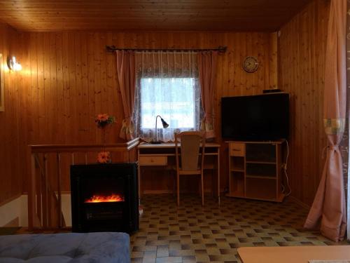 a living room with a desk and a fireplace at Ruhig gelegenes Ferienhaus in Simmelsdorf
