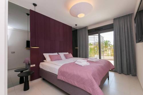 a bedroom with a large bed with pink sheets at Beferent Los Arenales playa 2 in Arenales del Sol