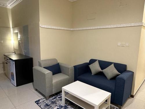 sala de estar con sofá azul y silla en المبيت 3 للشقق الفندقية en Abha