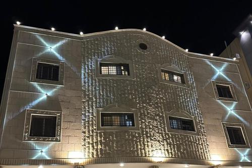 un edificio de piedra con luces encendidas por la noche en المبيت 3 للشقق الفندقية en Abha