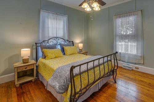 um quarto com uma cama e um candeeiro num piso de madeira em Quaint Anderson Home with Sunroom, Walk To Downtown! em Anderson