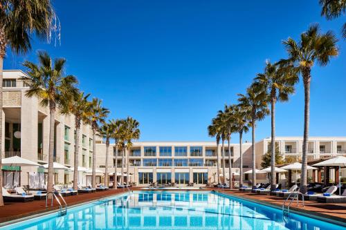a view of the resort with palm trees and a swimming pool at Anantara Vilamoura Family Friendly in Vilamoura