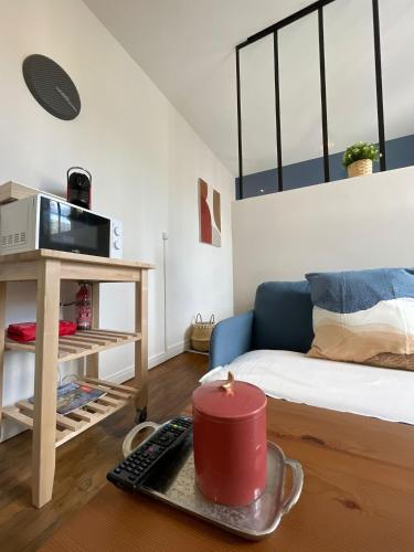 - un salon avec un canapé et une table avec une bougie dans l'établissement L'élégant du Grécourt, à Tours