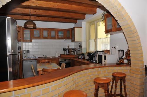 a kitchen with a brick counter with stools in it at Casa Napsugár Panzió in Apostag