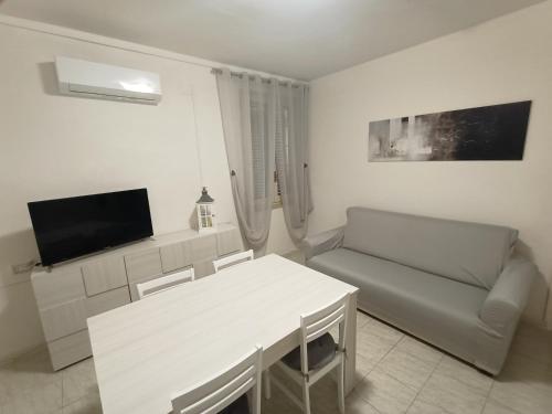 a white living room with a couch and a table at B&b da Elda Assisi in Bastia Umbra