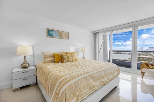 - une chambre blanche avec un lit et une grande fenêtre dans l'établissement Downtown SeaClusion, à Miami
