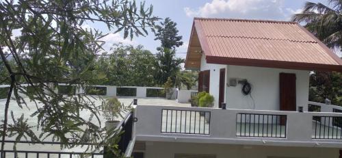 uma casa branca com um telhado vermelho em White Eco Villa em Kandy