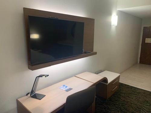 a room with a desk and a television on a wall at Courtyard by Marriott Hickory in Hickory