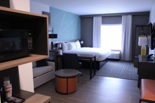 Habitación de hotel con cama y TV en Comfort Suites en Richmond